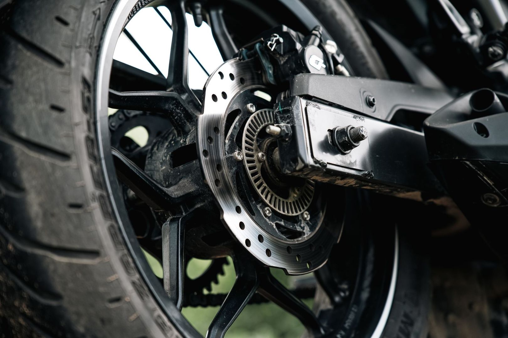 Close-up van een motorwiel met remschijf en aandrijfonderdelen